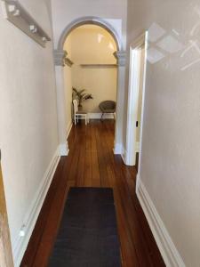 a hallway with an archway and a table and a chair at North Perth Stylish Character Home Close CBD in Perth