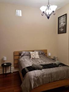 a bedroom with a bed and a chandelier at North Perth Stylish Character Home Close CBD in Perth