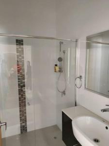 La salle de bains est pourvue d'une douche en verre et d'un lavabo. dans l'établissement North Perth Stylish Character Home Close CBD, à Perth
