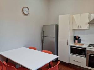 Il comprend une cuisine équipée d'une table blanche et d'un réfrigérateur. dans l'établissement North Perth Stylish Character Home Close CBD, à Perth
