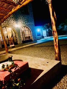un edificio di notte con un tavolo di fronte di Villa Maison des Arts - Oasis de Calme et Tranquillité Près de l'Aéroport d'Essaouira a Essaouira