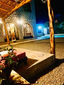 un edificio in pietra con una panchina di fronte ad esso di notte di Villa Maison des Arts - Oasis de Calme et Tranquillité Près de l'Aéroport d'Essaouira a Essaouira