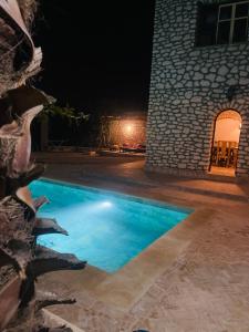 una piscina di fronte a un edificio di notte di Villa Maison des Arts - Oasis de Calme et Tranquillité Près de l'Aéroport d'Essaouira a Essaouira