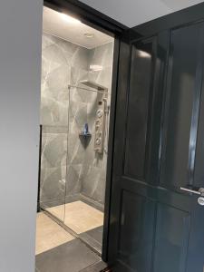 um chuveiro com uma porta de vidro na casa de banho em B&B Santorini em Maasbree