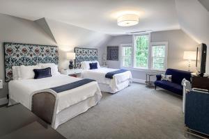 um quarto de hotel com duas camas e um sofá em The West Lane Inn em Ridgefield