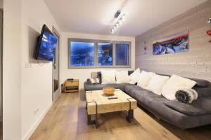 a living room with a couch and a table at Taragan - Totally Refurbished 3 bed apt, Central St Gervais! in Saint-Gervais-les-Bains