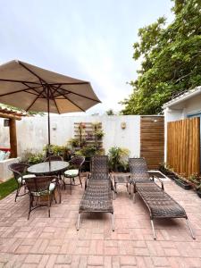 伊陶納斯的住宿－Pousada Vila Mar，庭院配有桌椅和遮阳伞。