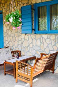 una mesa y un banco junto a una pared de piedra en Villa Angela, en Poličnik