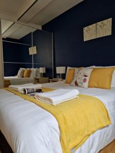 3 bedroom flat near Russel Sq في لندن: غرفة نوم بسريرين كبار وبطانيات صفراء
