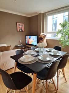 3 bedroom flat near Russel Sq في لندن: غرفة طعام مع طاولة مع كراسي وكلب