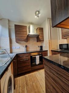 a kitchen with wooden cabinets and a washer at 3 bedroom flat near Russel Sq in London