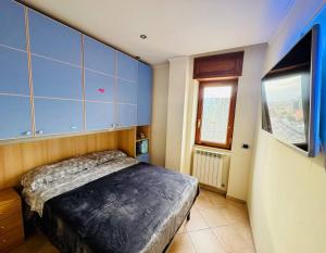een slaapkamer met een bed met blauwe kasten en een raam bij Napoli Centro in Napels