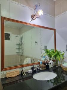 a bathroom with a sink and a large mirror at Palmy House Homestay Udonthani in Udon Thani