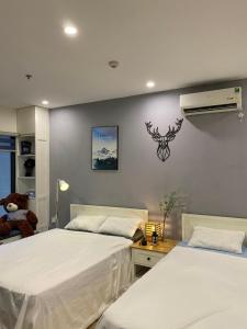 een slaapkamer met 2 bedden en airconditioning aan de muur bij Sora House 3 - Vinhomes Ocean Park in Hanoi