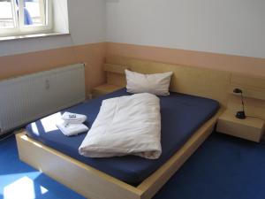 Una cama con sábanas blancas y toallas. en Hotel My Bed Dresden, en Dresden