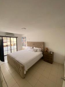 a bedroom with a large bed and a television at Casa ideal para familias estadías largas y cortas in Manta