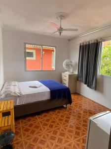 1 dormitorio con 1 cama y suelo de madera en Amares Hostel en Florianópolis