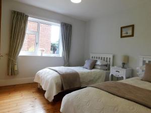a bedroom with two beds and a window at The Sidings in Sheringham