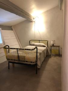 um quarto com duas camas e uma luz na parede em Gîte Figuier au Mas Dujau em Saint-Sauveur-de-Cruzières