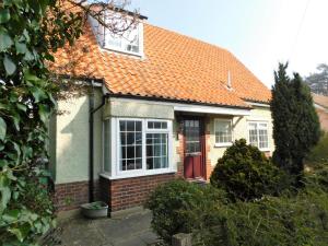 a house with an orange roof and a red door at Walma in West Runton