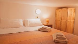 a bedroom with a bed with two towels on it at Accogliente Appartamento Foppolo in Foppolo