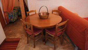 uma mesa de madeira com um cesto ao lado de um sofá em Accogliente Appartamento Foppolo em Foppolo