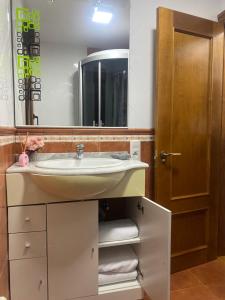 uma casa de banho com um lavatório e um espelho em Alojamiento Finca La Campa 