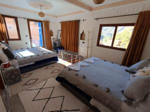 a bedroom with two beds and a window at Riad otos views in Imlil