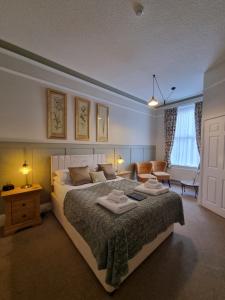 um quarto com uma cama grande e um sofá em The Cavendish em Scarborough