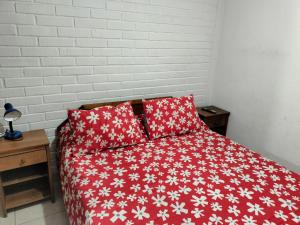 Una cama roja con dos almohadas rojas. en Hotel Angamos, en Santiago
