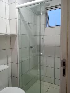 uma cabina de duche em vidro numa casa de banho com WC em Apartamentos com Vista pro Mar de Imbituba residencial mar azul em Imbituba