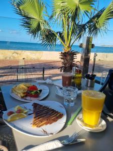 - une table avec des assiettes de nourriture et une vue sur la plage dans l'établissement Tanger Malabata, à Tanger