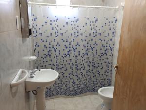 een badkamer met een douche, een wastafel en een toilet bij Departamento El Inca in Fiambala