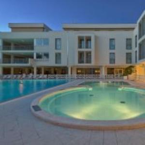 a large swimming pool in front of a building at Hotel Terme Marine Leopoldo II TERME & SPA in Marina di Grosseto