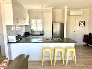 a kitchen with two yellow stools and a counter at Shackleton in Point Turton