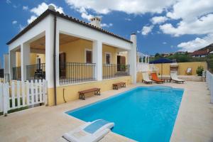 a villa with a swimming pool and a house at Villa Karavisianikos Faros in Karavádhos