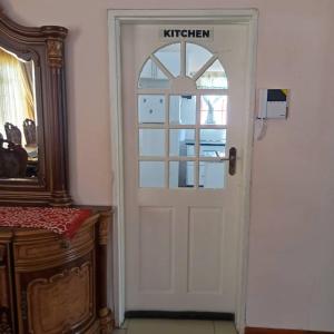 a white door with a sign on it next to a mirror at WaterBerry Guest House in Kasane