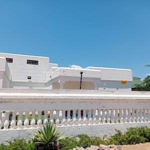 a white fence in front of a white building at WaterBerry Guest House in Kasane