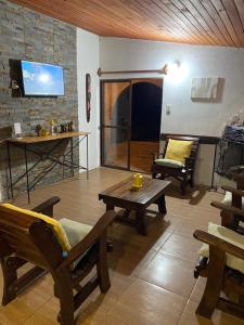 uma sala de estar com mobiliário em madeira e uma televisão em Posada Mahatma em Tacuarembó