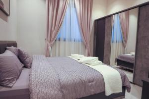 a bedroom with a bed with two towels on it at No 4 Luxury Villa Compound Al Nada 4 King BedRooms, 5 BathRooms, Two Living Rooms w Smart TVs, 6 Seater Dinning Table, General Swimming Pool, Gym, 4 Seater Outdoor Dinning Table in Riyadh
