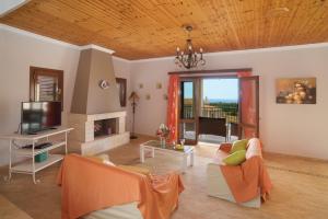 a living room with a couch and a tv at Villa Karavisianikos Faros in Karavádhos