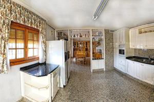 a kitchen with white cabinets and a white refrigerator at El Carrascal in Caravaca de la Cruz +17 photos