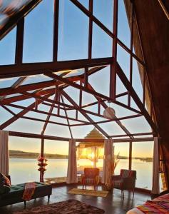 プーノにあるGlamping Titicaca Perúの水辺の景色を望む大きな窓が備わる客室です。