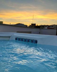 duży basen z zachodem słońca w tle w obiekcie Santeria Modern Loft w mieście Tortolì