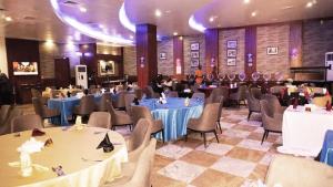 un salón de banquetes con mesas y sillas y un hombre en una habitación en Airport GoldenTulip Hotel en Lagos