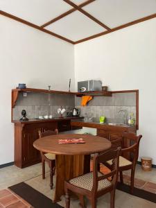 cocina con mesa de madera con sillas y barra en Lobo's Villa en Kurunegala