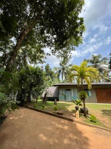 a house with palm trees in front of a driveway at Lobo's Villa in Kurunegala