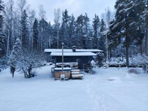 a small cabin in the snow with trees at Cottage by the sea in Turku