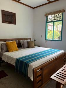 a bedroom with a large bed with yellow and blue sheets at Lobo's Villa in Kurunegala
