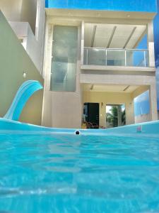 une maison avec une piscine dotée d'un toboggan dans l'établissement Casa de temporada Camocim, à Camocim
